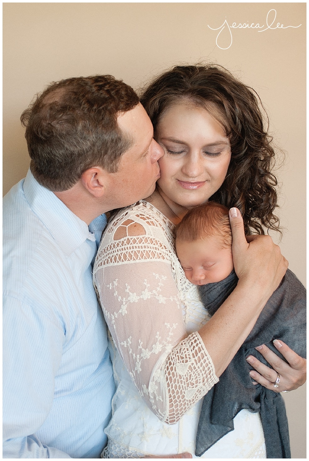 newborn photographer broomfield, dad kissing mom with newborn