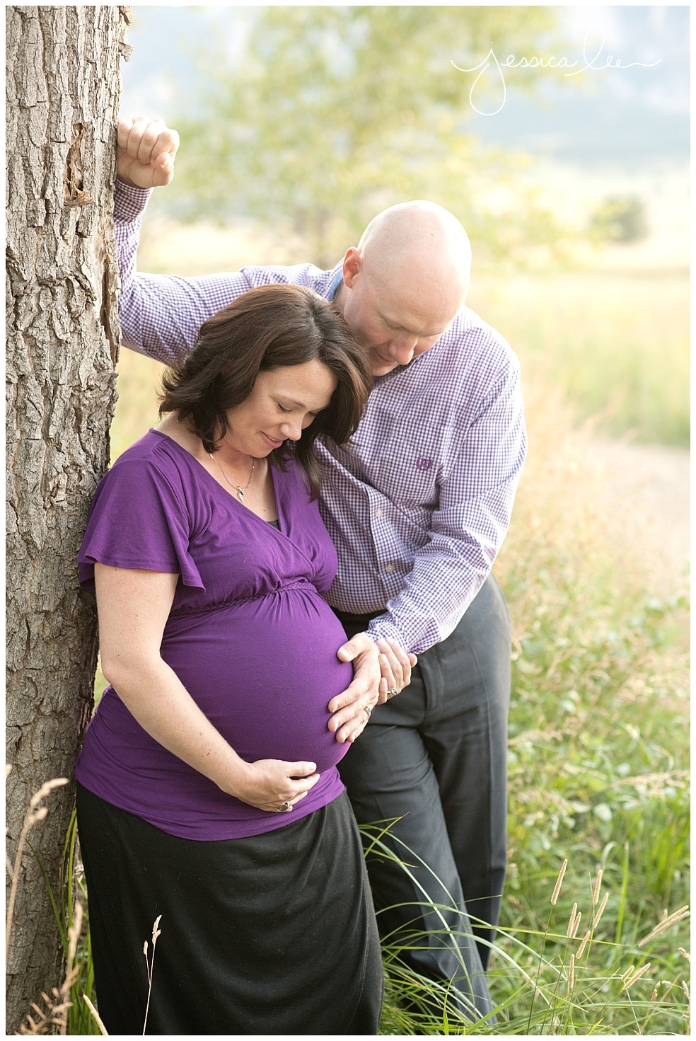 expecting mother by tree with husband in purple shirt, colorado maternity photographer