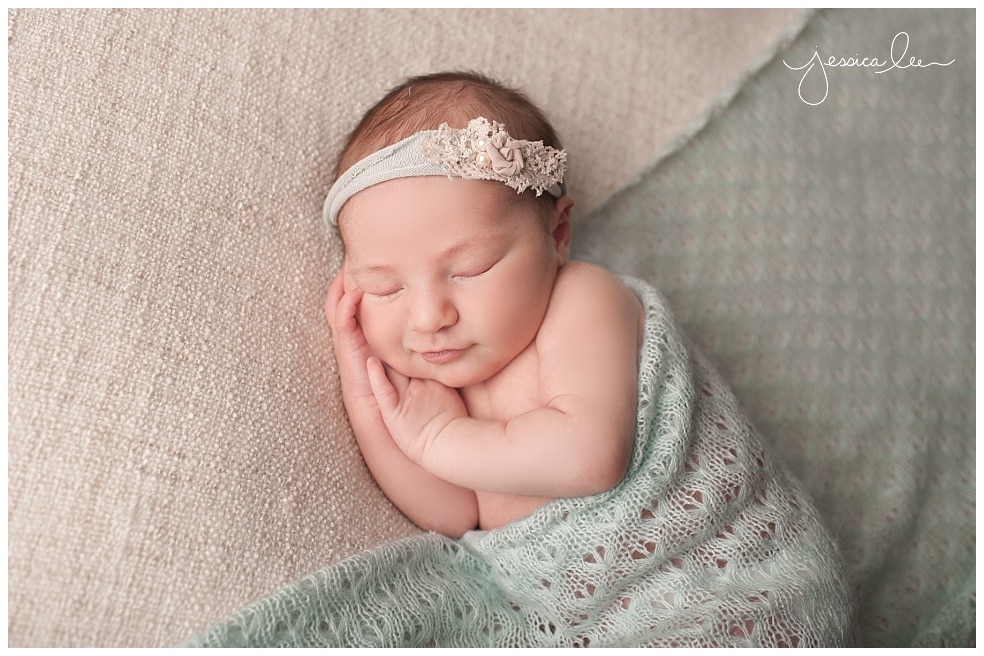 newborn giving little smile with teal blanket, Boulder Baby Photographer,