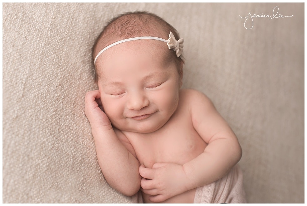 newborn smiling with little bow on head, Boulder Baby Photographer,