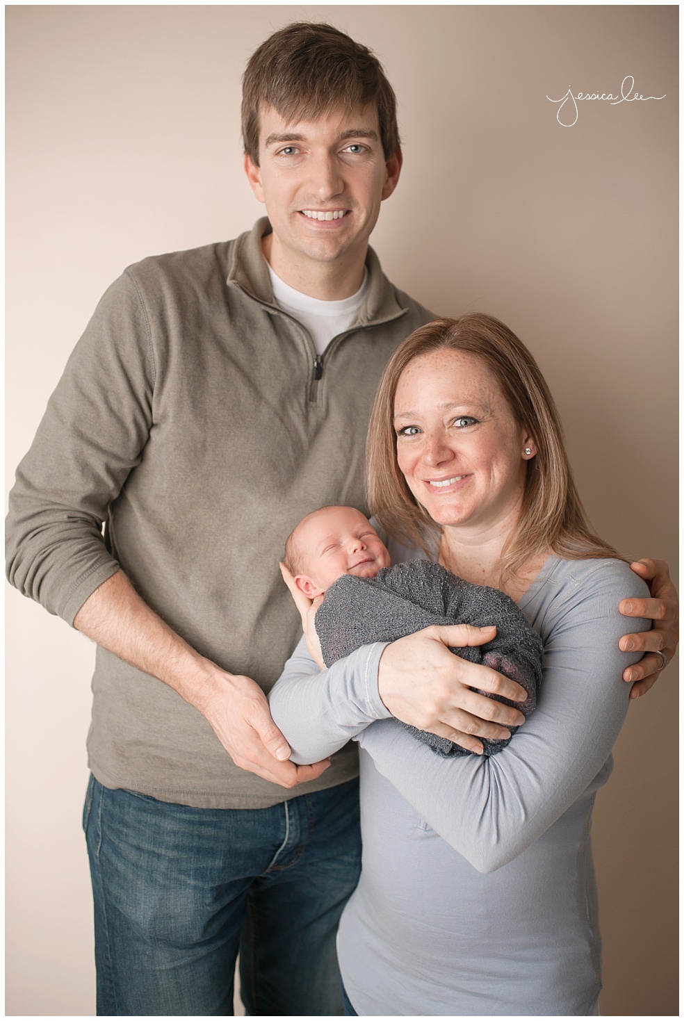 family portrait of three, baby smiling with mom and dad