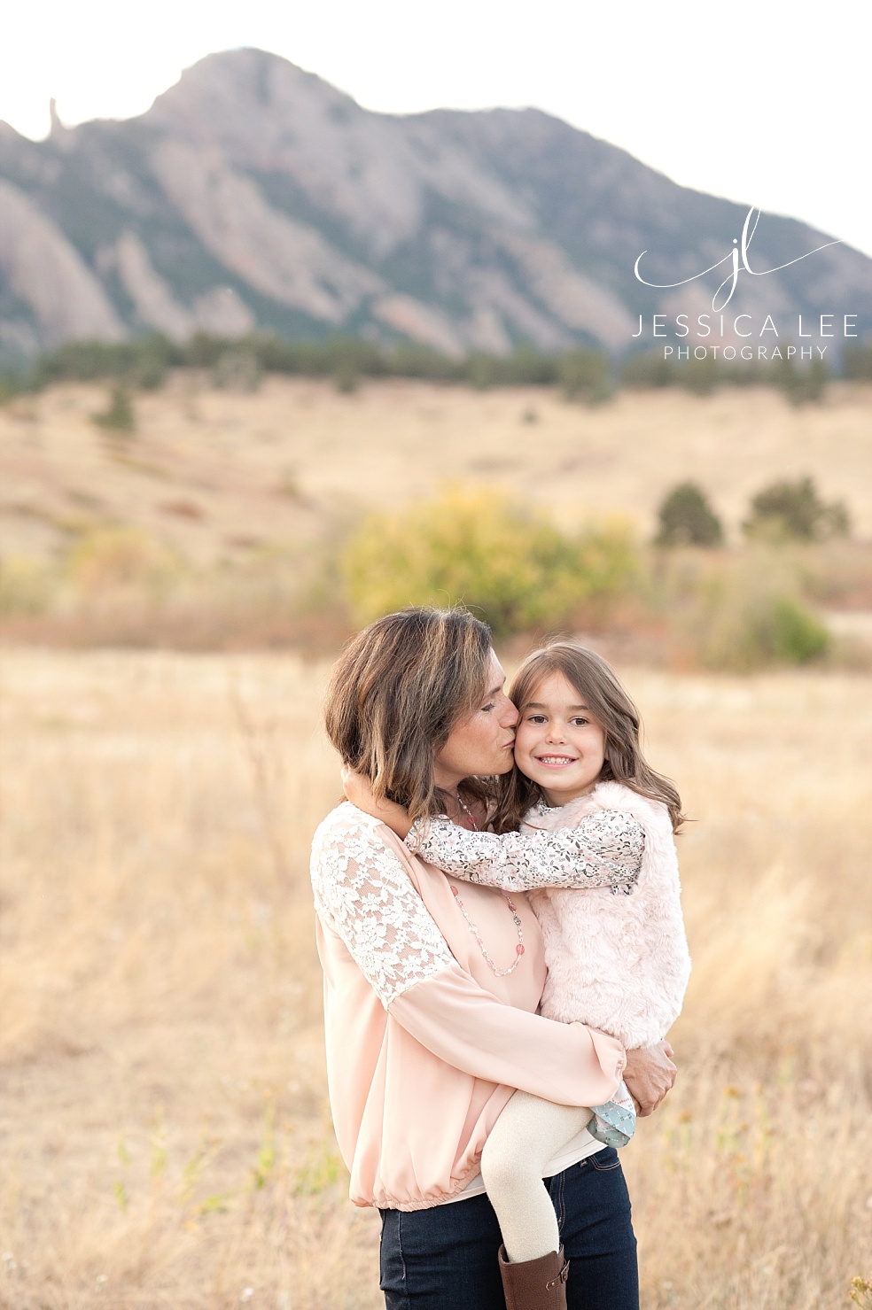 Broomfield Colorado Family Photographer, mother kissing daughter in front of mountains