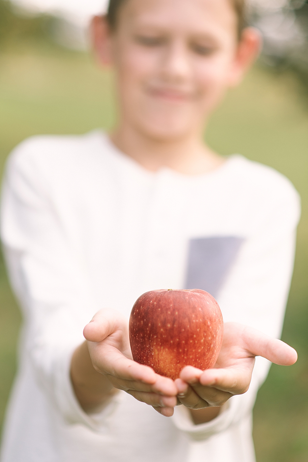 Detail photo of little boy holding an apple | Photo by Jessica Lee Photography
