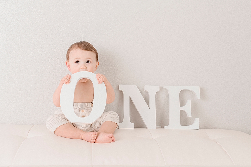 Baby boy playing with letters that spell "one" | Photo by Jessica Lee Photography