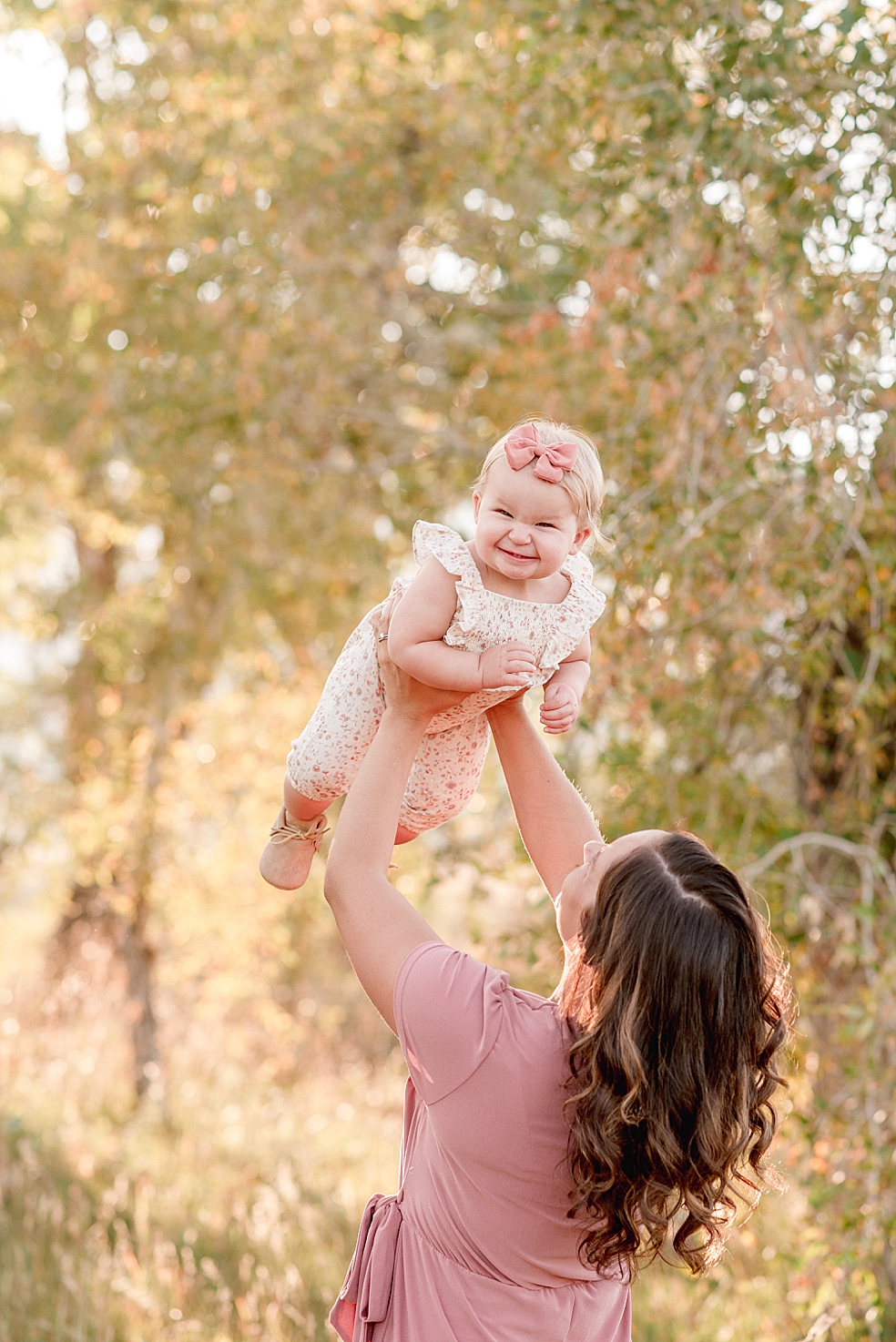 Mom in pink dress playing with baby girl | Photo by Jessica Lee Photography