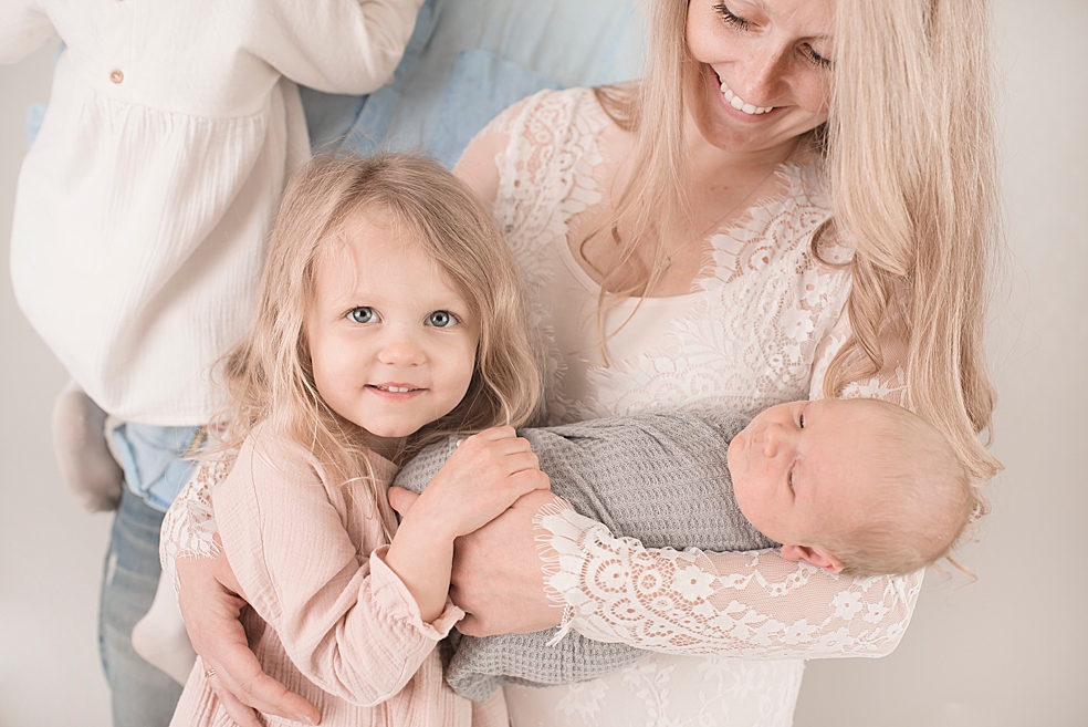 Detail photo of sister and family snuggling newborn baby boy | Photo by Jessica Lee Photography