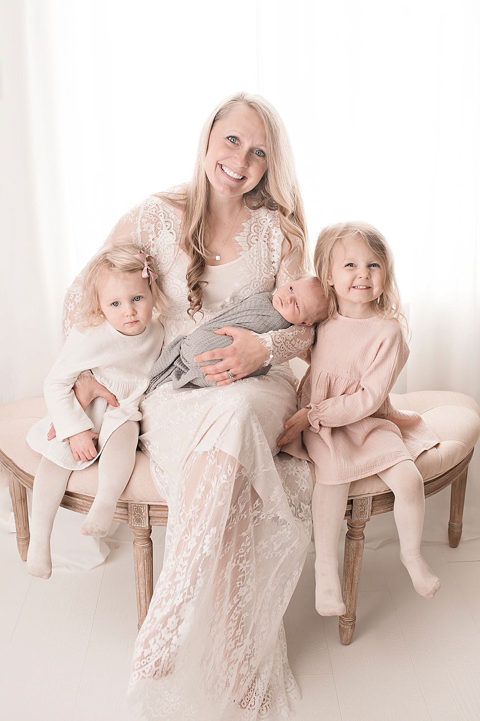 Mom and daughters holding their new baby | Photo by Jessica Lee Photography