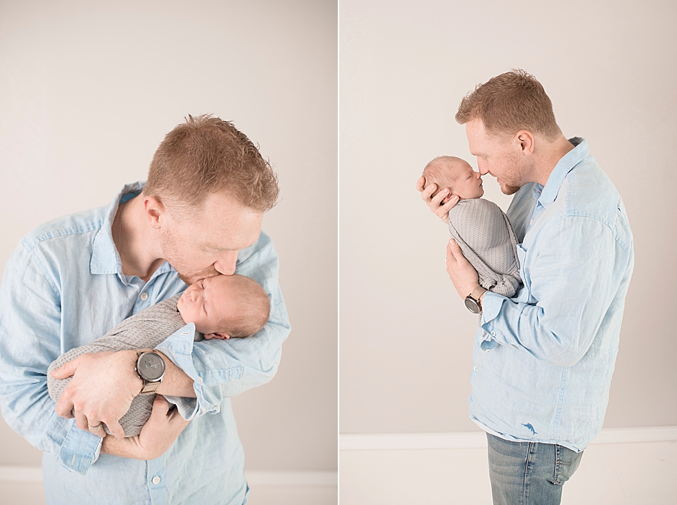Dad in blue shirt snuggling newborn baby boy | Photo by Jessica Lee Photography
