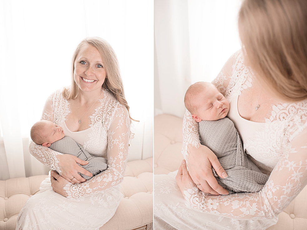 Mom in lace dress holding newborn baby boy wrapped in gray swaddle | Photo by Jessica Lee Photography