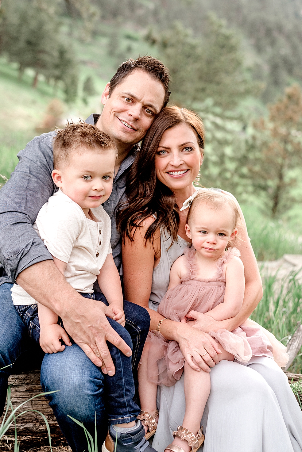 Family of four smiling at the camera | Photo by Jessica Lee Photography