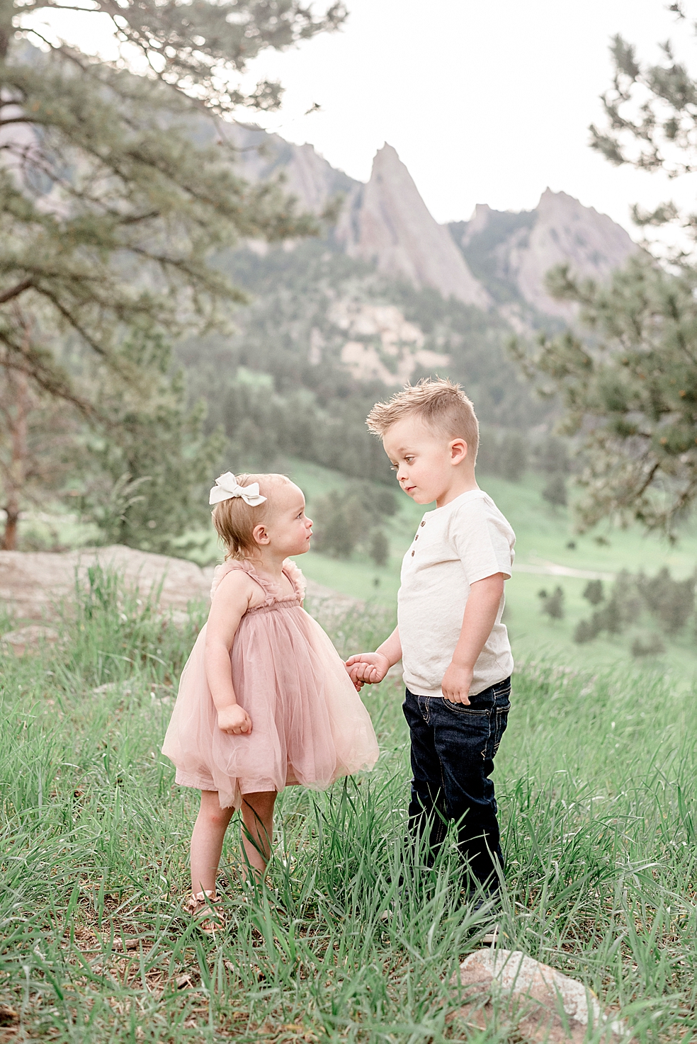 Little brother in cream and sister in pink holding hands | Photo by Jessica Lee Photography