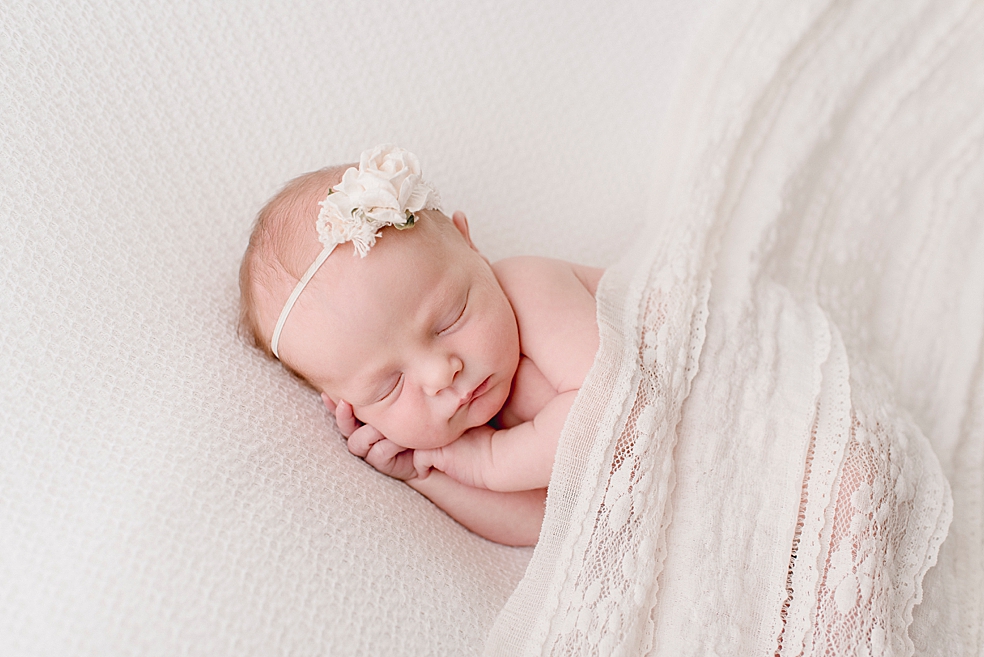 Sleeping newborn in lace swaddle and headband | Photo by Jessica Lee Photography