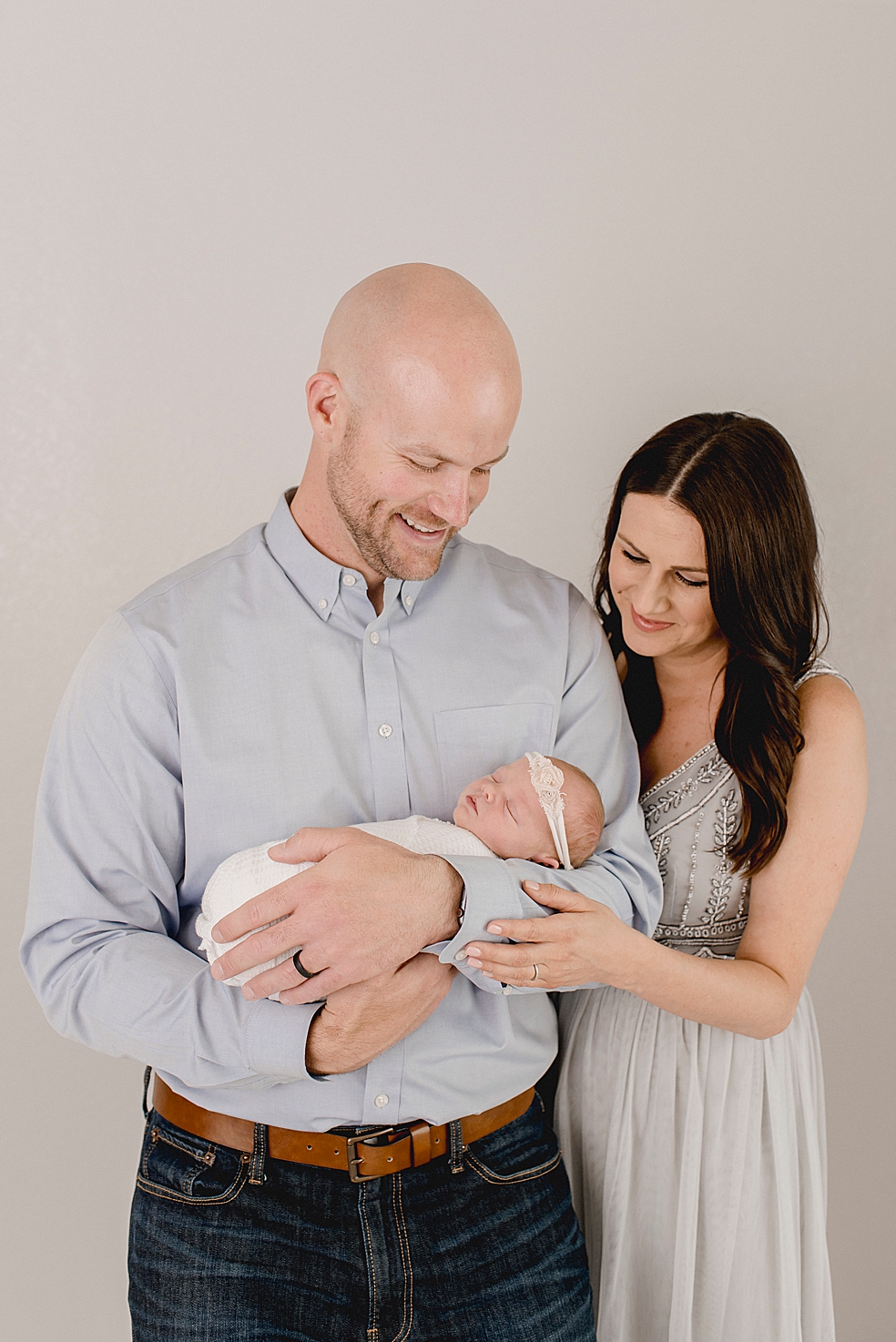 New mom and dad holding newborn baby girl | Photo by Jessica Lee Photography