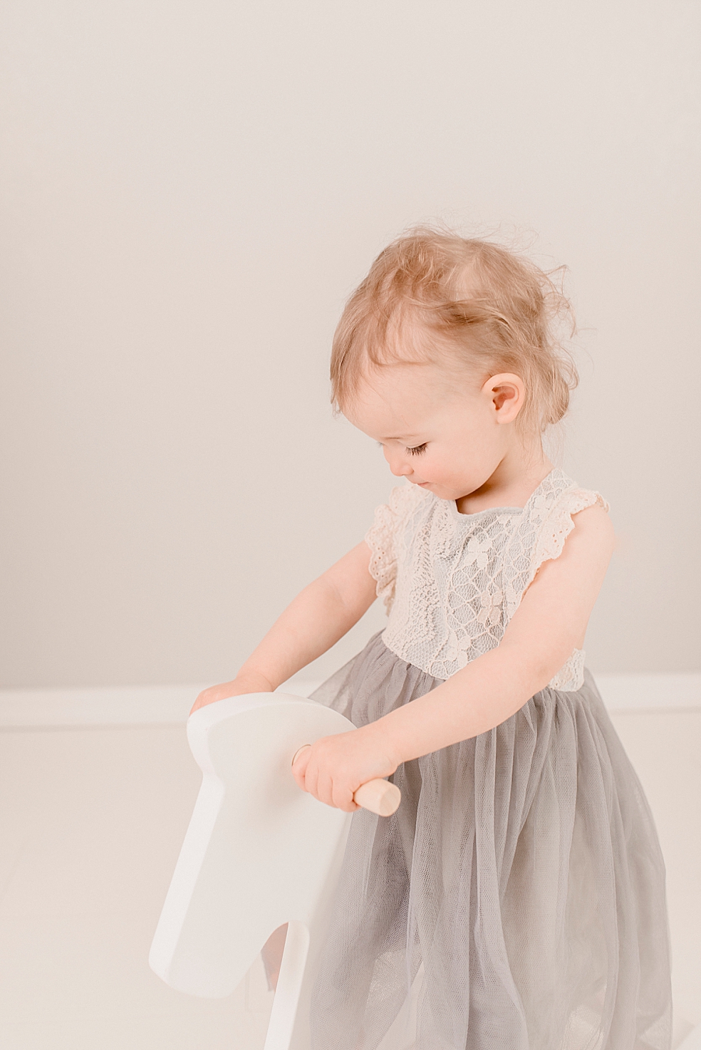 Little girl in gray tutu on white rocking horse | Photo by Jessica Lee Photography