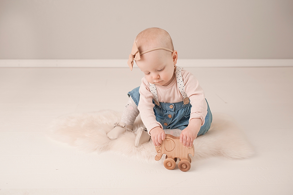Toddler baby girl in polka dots playing with a wooden elephant | Photo by Jessica Lee Photography 