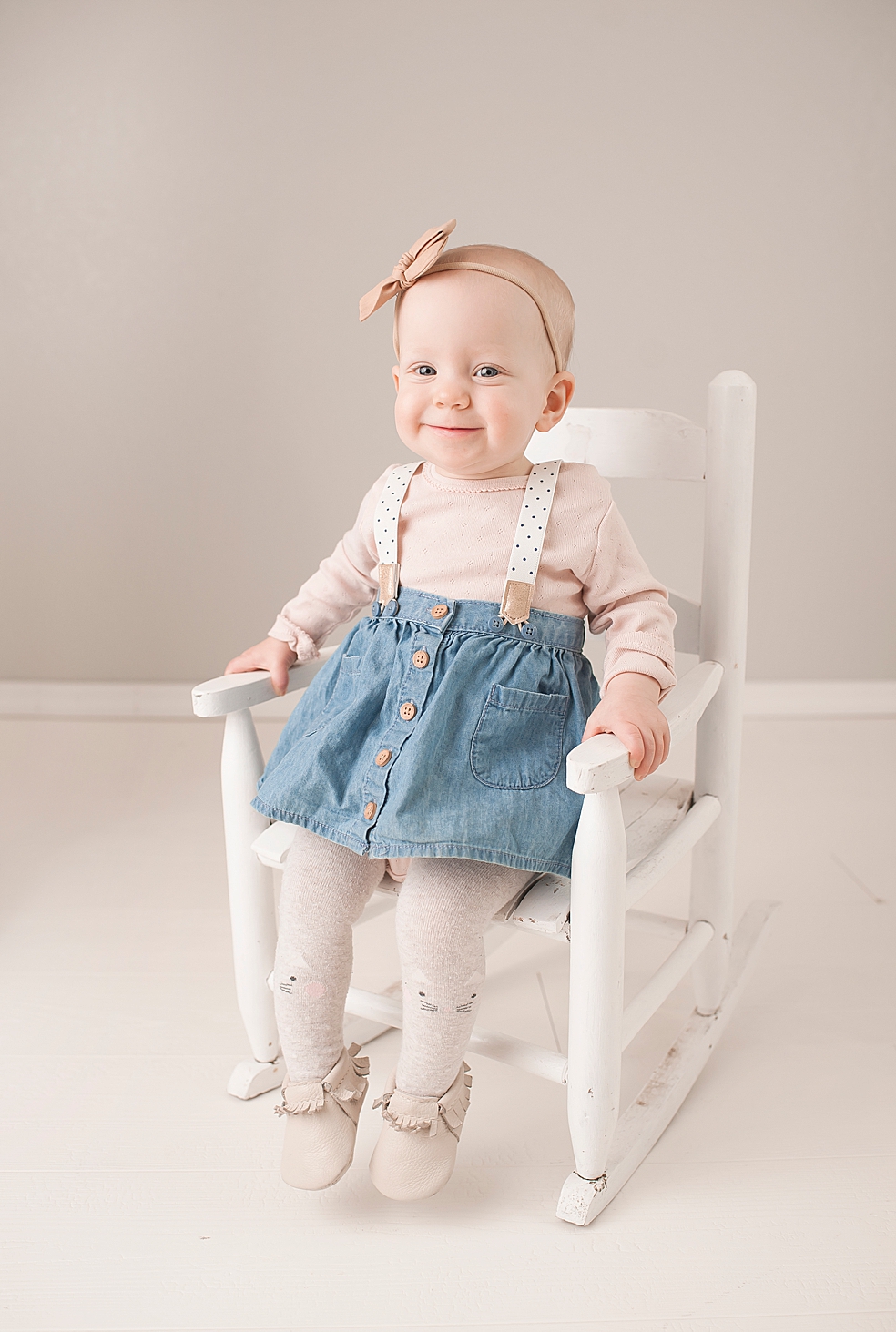 Smiling toddler girl in a white rocking chair | Photo by Decatur Alabama Baby Photographer Jessica Lee 