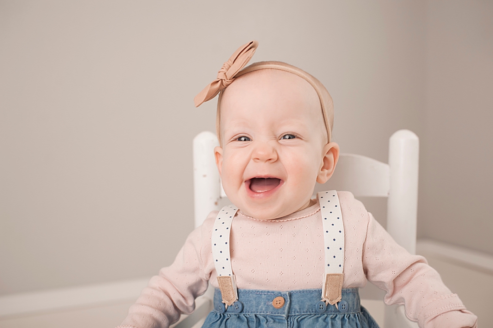 Baby girl smiling sitting in a rocking chair | Photo by Jessica Lee Photography 