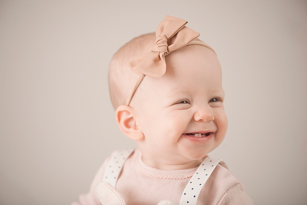 Baby girl smiling wearing a pink bow headband | Photo by Decatur Alabama Baby Photographer Jessica Lee 