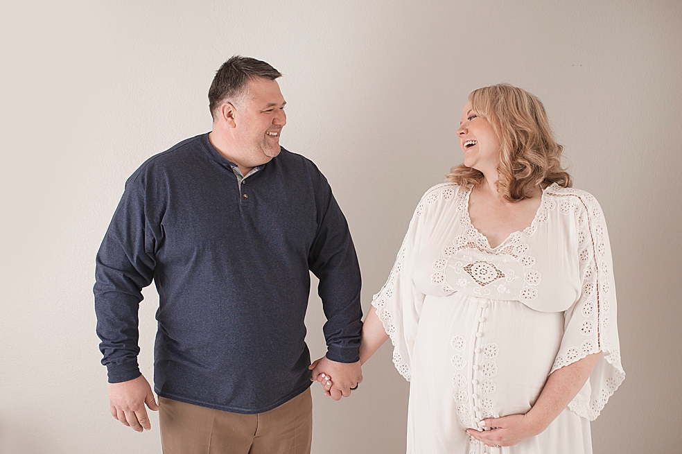 Mom and dad holding hands and laughing | Photo by Jessica Lee Photography