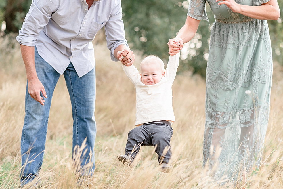 Mom and dad swinging their toddler baby boy | Photo by Madison Alabama Baby Photographer Jessica Lee 