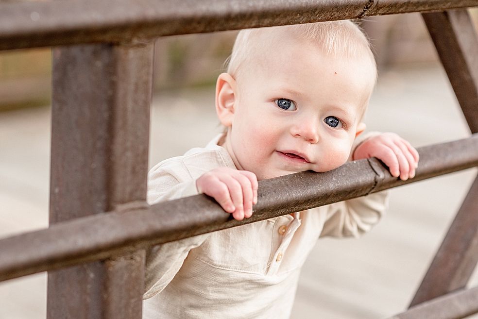 Toddler boy looking through bridge slats | Photo by Jessica Lee Photography 