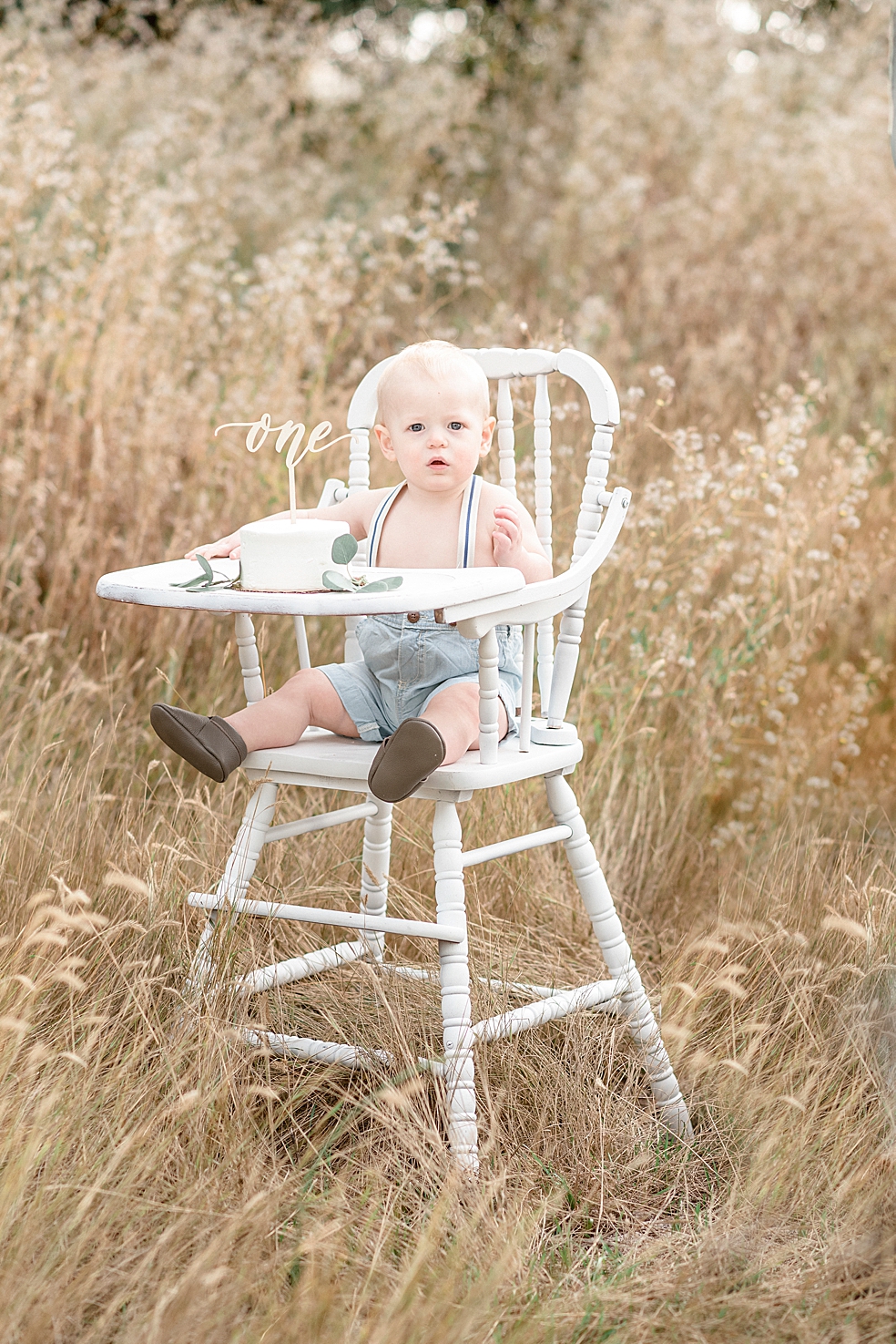 Baby boy in white highchair with smash cake | Photo by Madison Alabama Baby Photographer Jessica Lee