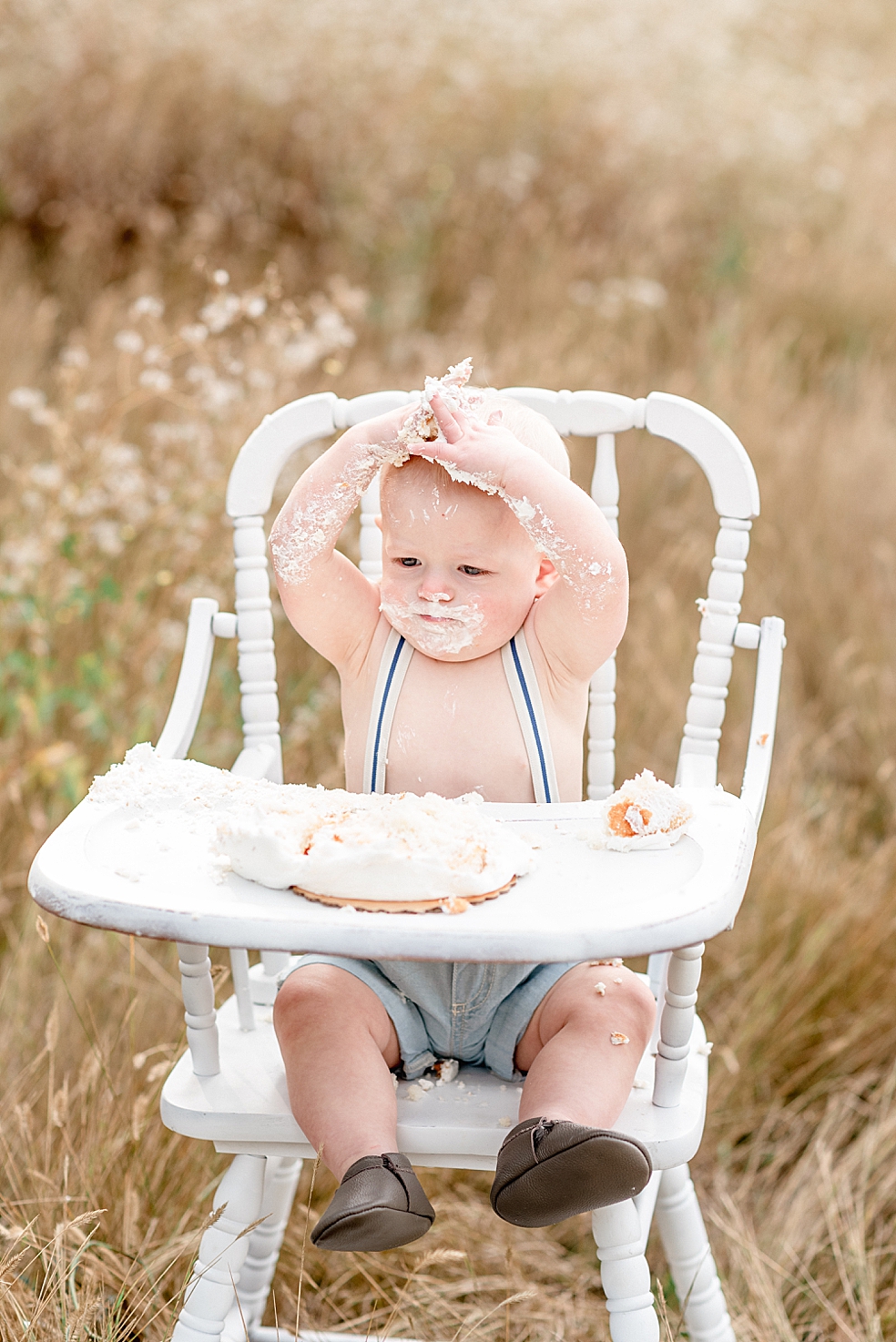 Baby boy in suspenders eating cake | Photo by Jessica Lee Photography 