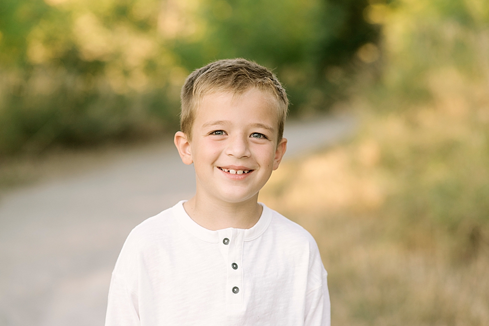 Little boy smiling in white crew long sleeve | Photo by Madison Alabama Family Photographer Jessica Lee
