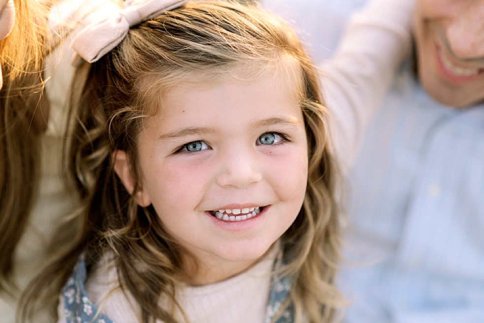 Little girl with brown hair and a pink bow | Photo by Madison Alabama Family Photographer Jessica Lee