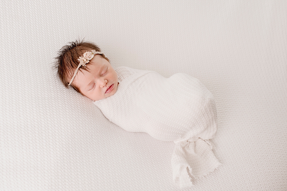 Sleeping newborn wrapped in white swaddle | Photo by Madison Alabama Newborn Photographer Jessica Lee 