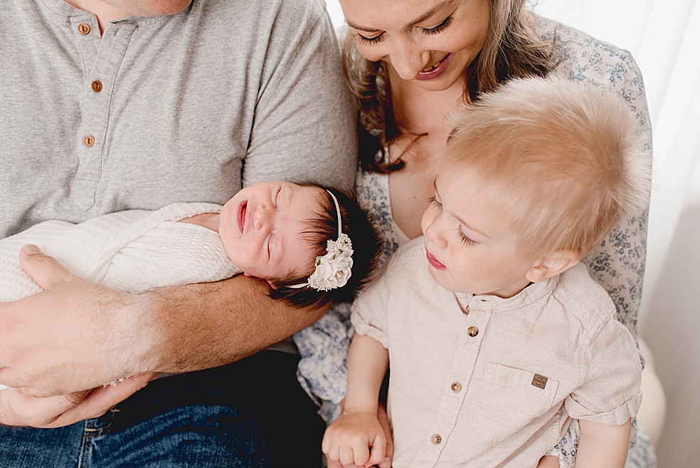 Family with toddler boy admiring their new baby girl | Photo by Jessica Lee Photography 