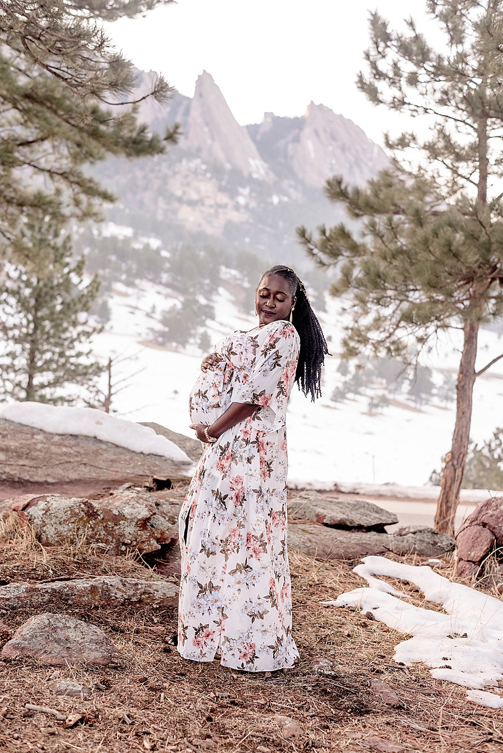 Mom to be in floral dress holding her belly | Photo by Jessica Lee Photography