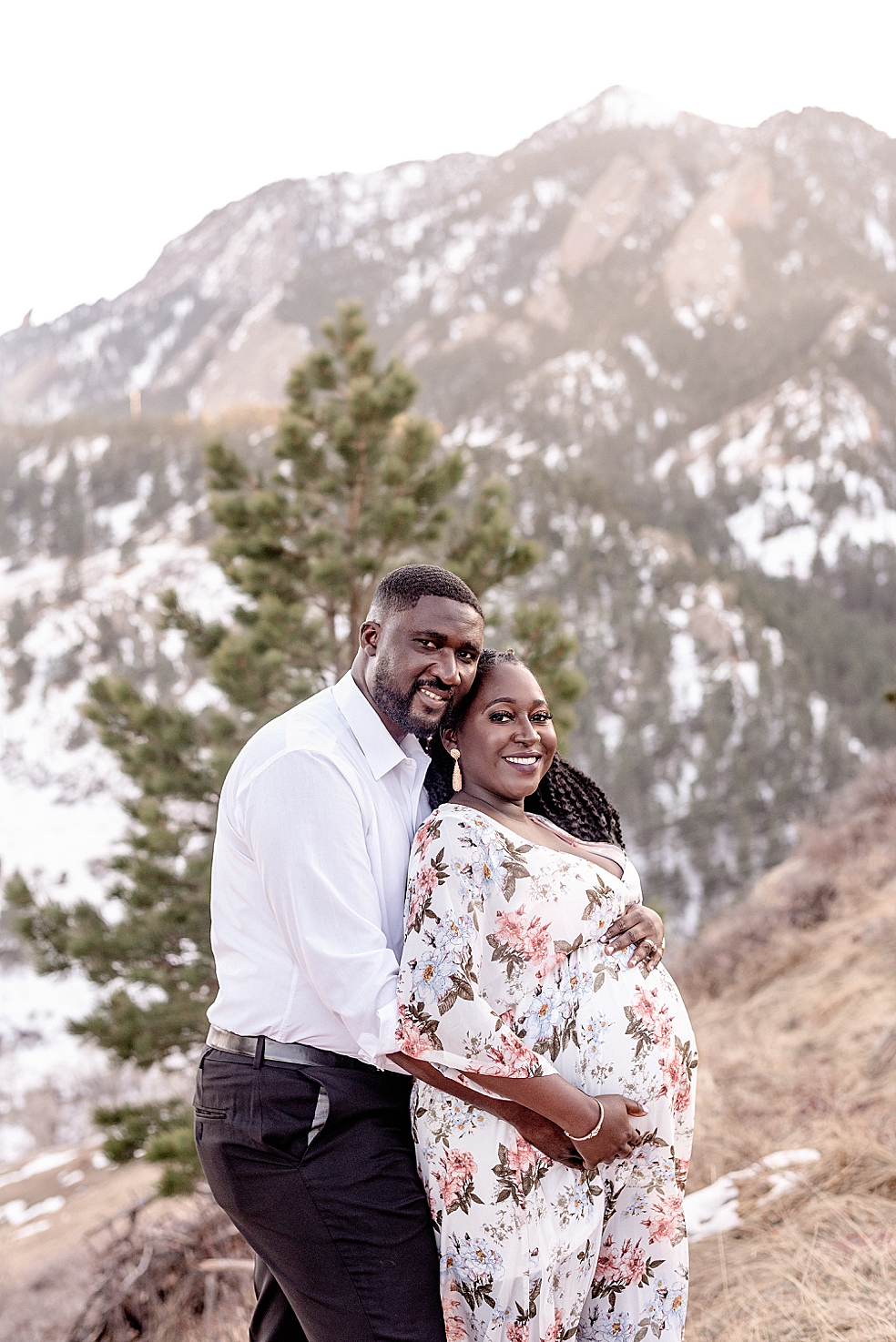 Mom and dad smiling together while holding moms belly | Photo by Jessica Lee Photography