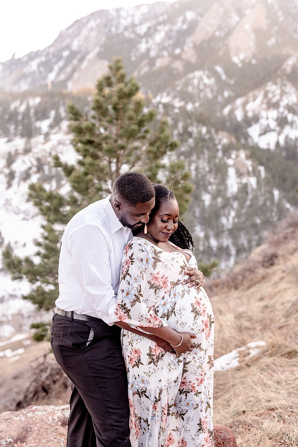 Mom and dad to be snuggling together near the mountains | Photo by Huntsville Motherhood Photographer Jessica Lee Photography