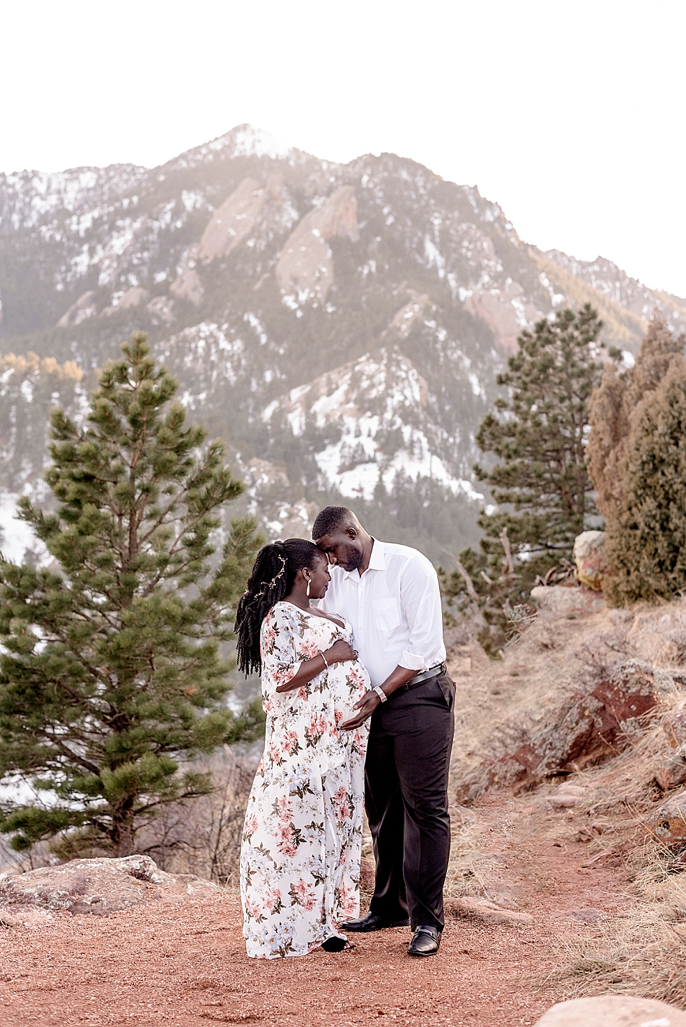 Mom and dad to be snuggling together in front of mountains | Photo by Huntsville Motherhood Photographer Jessica Lee Photography