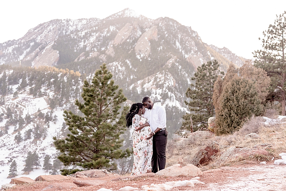 Mom and dad to be with foreheads together standing in front of mountains | Photo by Jessica Lee Photography