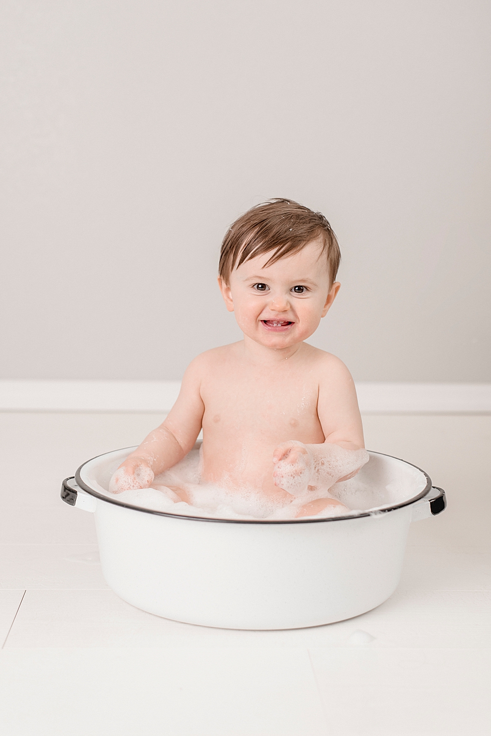 Baby boy in a bathtub smiling | Photo by Jessica Lee Photography