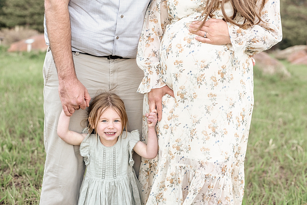 Details of little girl holding her mom and dad's hands | Photo by Meridianville Maternity Photographer Jessica Lee
