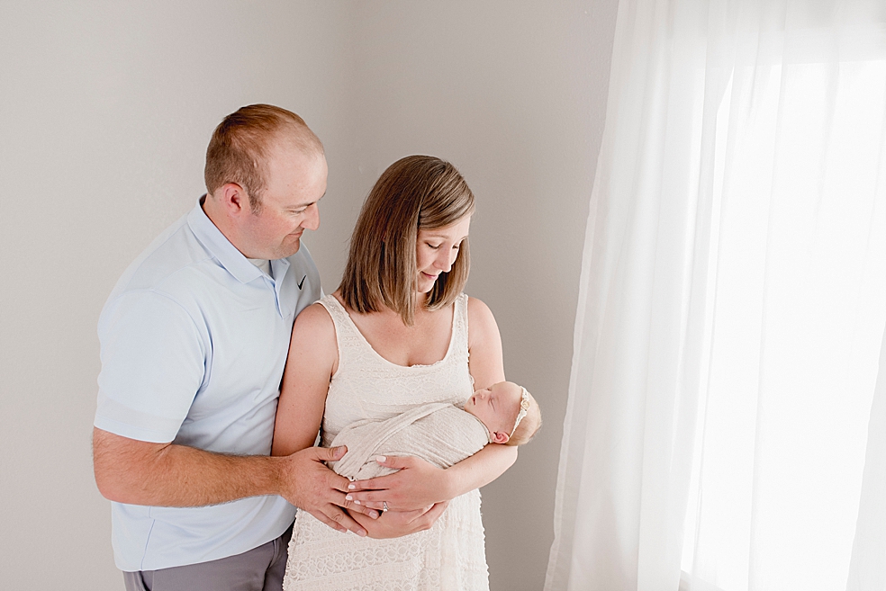 Mom and dad holding their newborn baby girl | Photo by Meridianville Newborn Photographer Jessica Lee