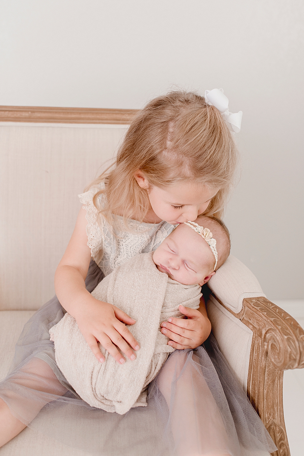 Big sister snuggling her newborn baby sister | Studio Newborn Session with Jessica Lee Photography