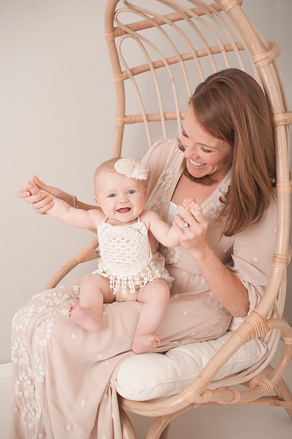 Mom wearing soft pink dress holding her baby girl | Photo by Jessica Lee Photography