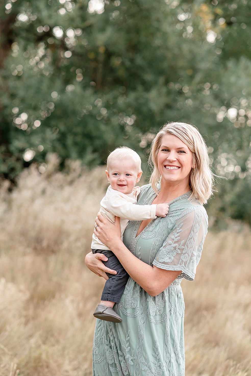 Mom in a sea foam green dress holding her little boy | Photo by Jessica Lee Photography