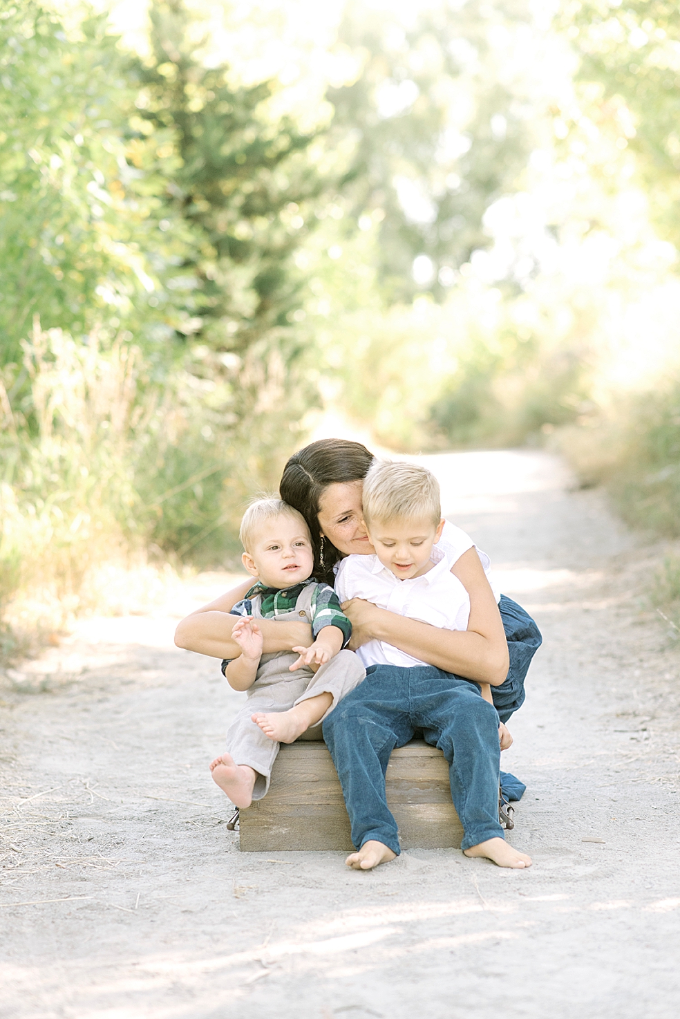 Mom snuggling with her two little boys | Photo by Jessica Lee Photography