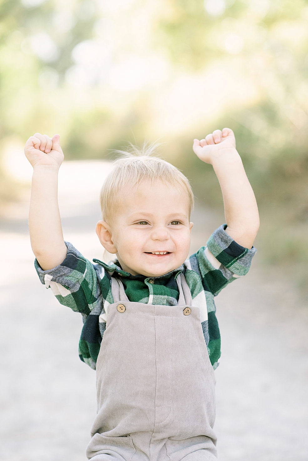 Little boy in plaid and overalls laughing | Photo by Jessica Lee Photography