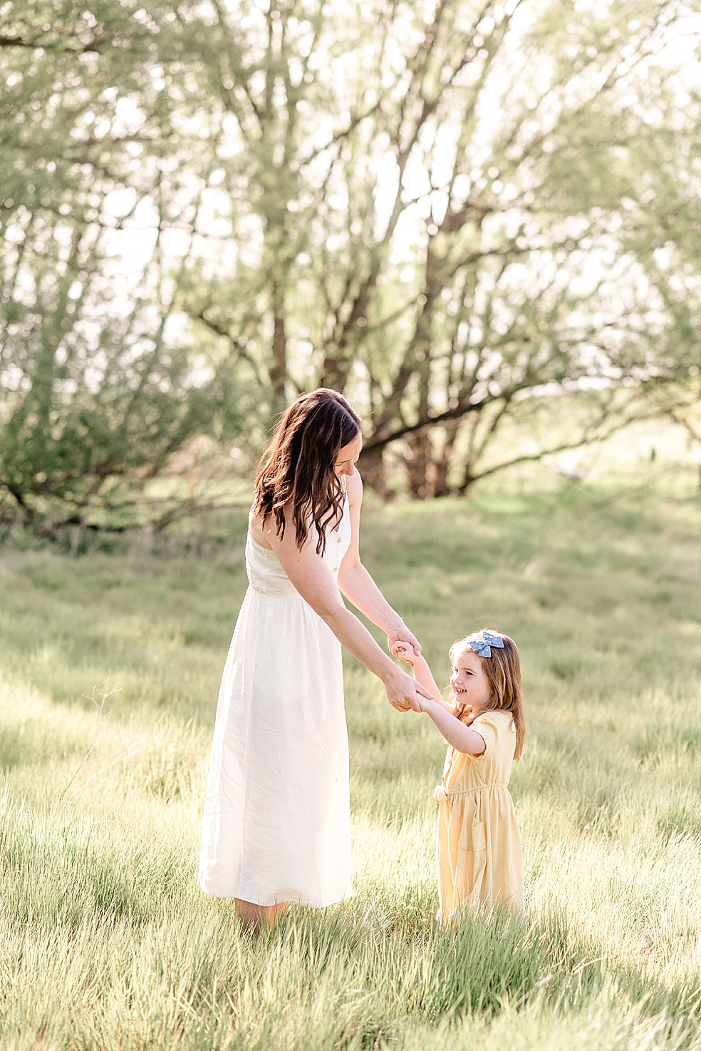 Mom and daughter dancing in a field | Photo by Jessica Lee Photography