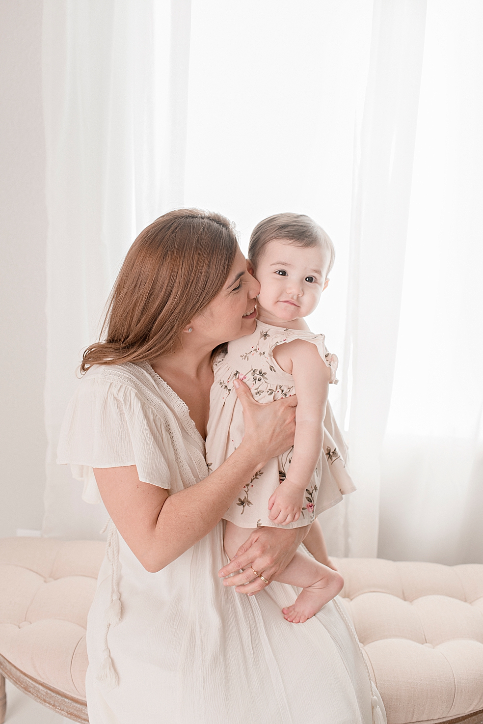 Mom kissing her baby girl during their studio session | Photo by Jessica Lee Photography