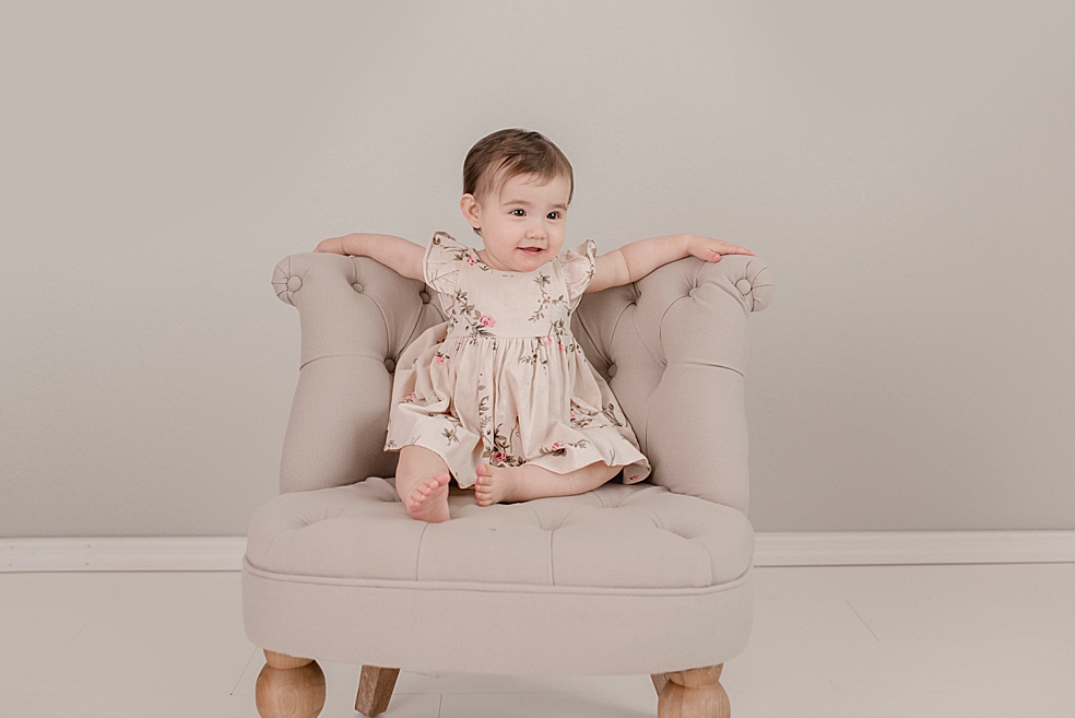 Baby girl sitting in a chair during her light and airy studio session | Photo by Jessica Lee Photography