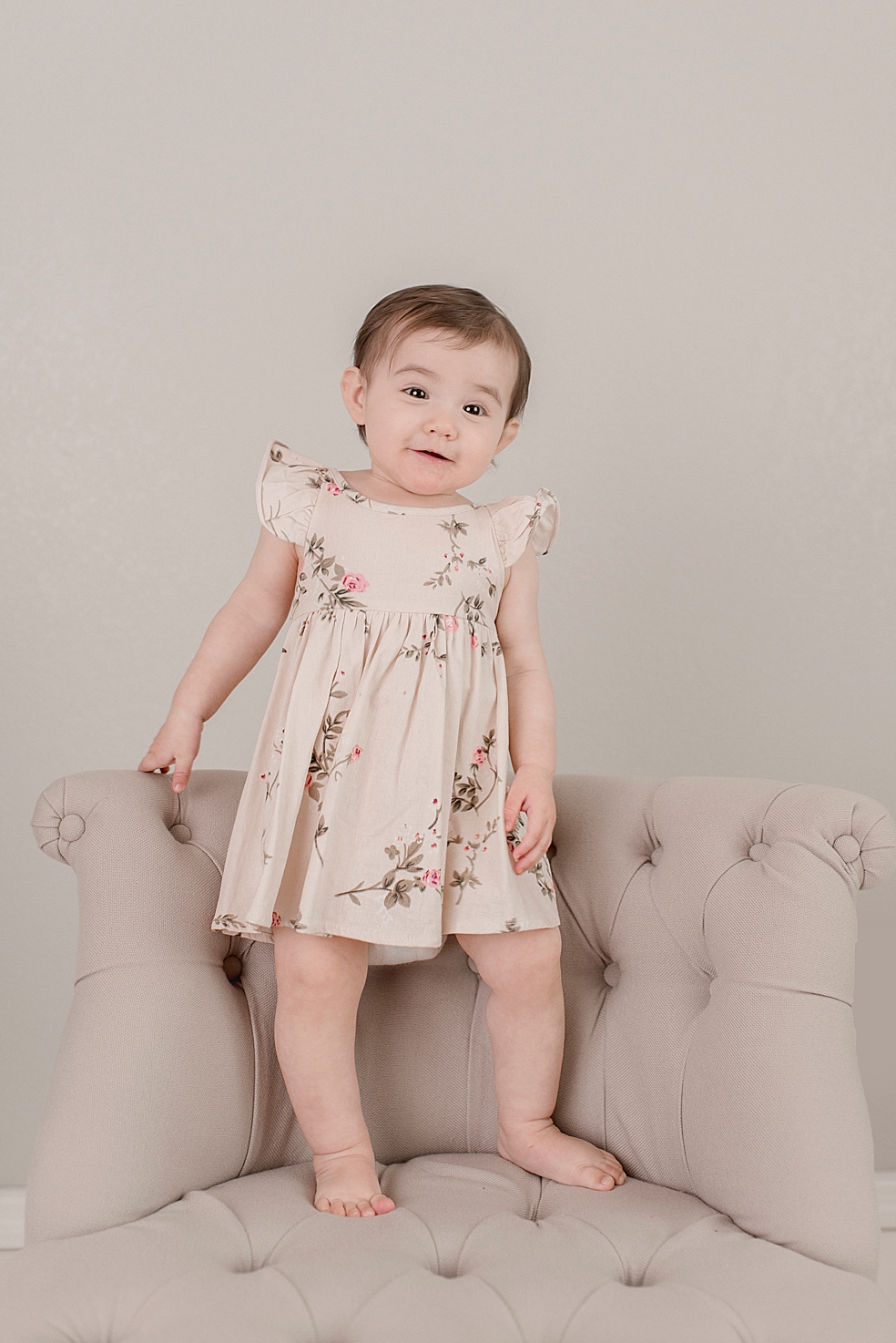 Baby girl in a floral print dress smiling | Photo by Jessica Lee Photography