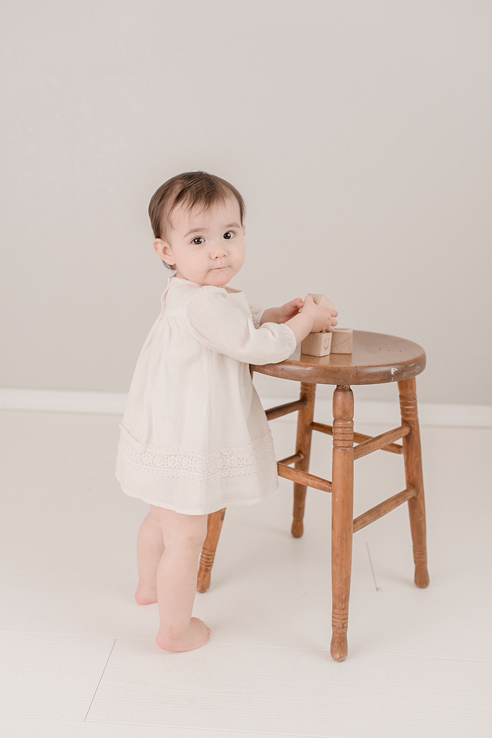 Baby girl playing with wooden blocks during her light and airy studio session | Photo by Jessica Lee Photography