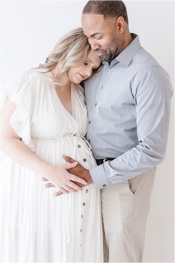 Woman and Man hugging while holding belly, Timeless Studio Maternity Session, Jessica Lee Photography